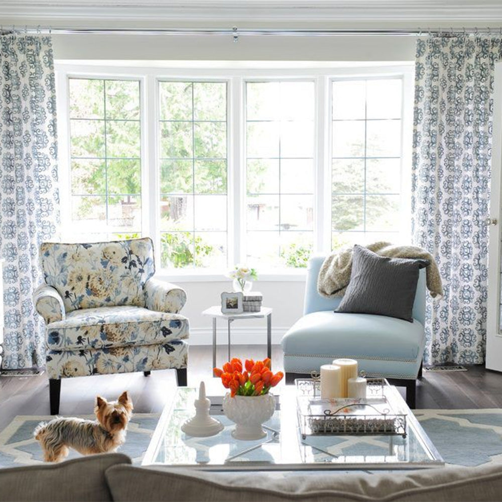 A printed sofa chair and a light blue slipper chair